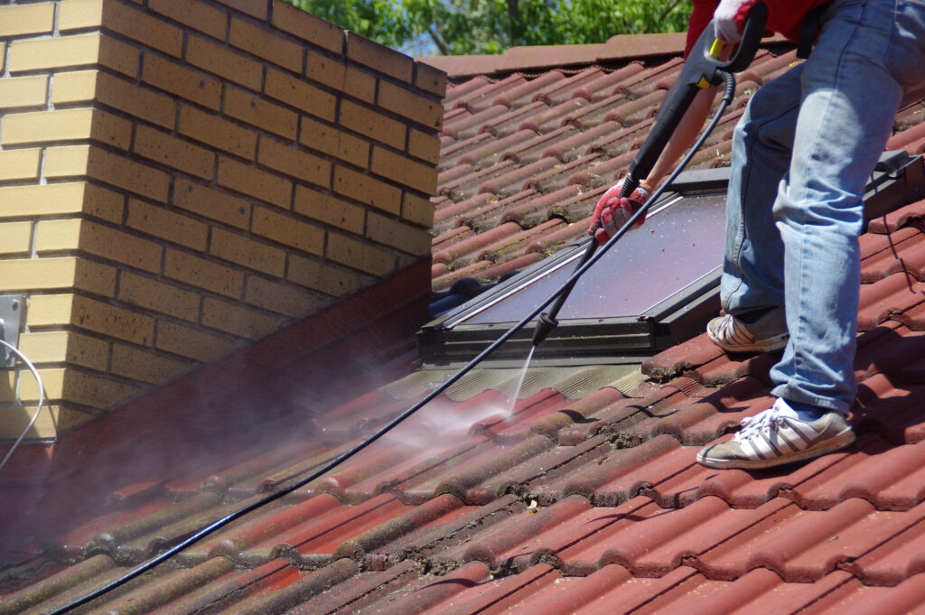 The Top 5 Roofing Services Every Homeowner Should Know About » Newcastle Trades roof cleaning using water spray.